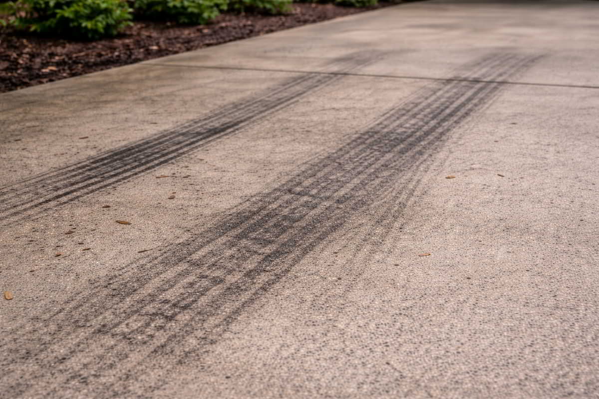 Rubber tire marks on concrete driveway